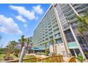 High-rise condo building with multiple balconies, outdoor seating, and walkway to the beach at 201 74Th Ave. N # 1128, Myrtle Beach, SC 29572