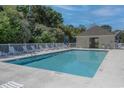 Community pool area with lounge chairs, a fence, and a nearby building with a covered area at 221 Port Smith Dr. # 6, Myrtle Beach, SC 29588