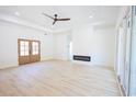 Spacious living room boasting new wood floors, white walls, a ceiling fan and a modern fireplace at 232 Ole Maple St., Loris, SC 29569