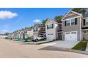 Street view of townhomes, each with attached one-car garages and driveways at 247 Christiana Ln. # D, Myrtle Beach, SC 29579