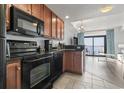 Functional kitchen with modern black appliances, wooden cabinetry, and a pass-through to the living area at 2600 N Ocean Blvd. # 807, Myrtle Beach, SC 29577