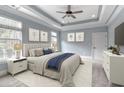 Serene main bedroom with a tray ceiling, soft color palette, a ceiling fan, and large windows at 2935 Moss Bridge Ln., Myrtle Beach, SC 29579