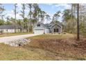 Charming home featuring a two-car garage, stone accents, and complemented by a beautifully landscaped front yard at 480 N Boundaryline Dr. Nw, Calabash, NC 28467