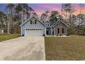 Charming home featuring a two-car garage, stone accents, and complemented by a beautifully landscaped front yard at 480 N Boundaryline Dr. Nw, Calabash, NC 28467