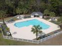 Resort-style pool and jacuzzi with white picket fence, palm trees, and lounge chairs at 524 Pinehurst Ln. # 19D, Pawleys Island, SC 29585