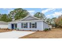 Cozy home with light blue siding, a new driveway, and manicured shrubs in the front at 620 Culmen Ct., Myrtle Beach, SC 29588