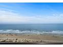 Expansive ocean view featuring sandy beach with people relaxing on the beautiful shores at 6804 N Ocean Blvd. # 1127, Myrtle Beach, SC 29572