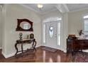 Inviting foyer featuring a hardwood floor, a decorative table, a mirror, and a lovely front door at 9278 Nw Checkerberry Square, Calabash, NC 28467