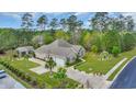 An aerial view of a single story brick home with a well manicured lawn and mature landscaping at 152 Creek Harbour Circle, Murrells Inlet, SC 29576