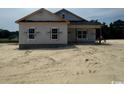Newly constructed home with gray siding, black shutters, and an unfinished yard at 334 William Nobles Rd., Aynor, SC 29511