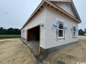 Unfinished exterior of a two-car garage showcasing unfinished siding and double windows at 334 William Nobles Rd., Aynor, SC 29511