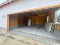 Unfinished two-car garage features concrete flooring, a back door, and an open ceiling at 334 William Nobles Rd., Aynor, SC 29511