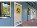 Condo entrance featuring a lovely door with a yellow wreath, a window, and wooden flooring at 610 Putters Ln. # H-109, Little River, SC 29566