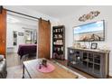 Bright living room with a TV, decor, shelving, and an open entrance into the bedroom at 610 Putters Ln. # H-109, Little River, SC 29566