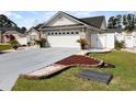 Charming exterior view featuring a brick facade, well-maintained landscaping, and a two-car garage at 657 Lantern Ct., Longs, SC 29568