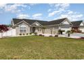 Well-maintained single-Gathering home featuring a landscaped front yard and a classic brick and siding facade at 657 Lantern Ct., Longs, SC 29568