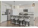 Modern kitchen featuring granite countertops, stainless steel appliances, ample white cabinetry, and a breakfast bar at 7037 Grant St., Little River, SC 29566