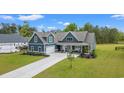 Beautiful home exterior with blue siding, large front yard, long driveway, and a basketball hoop for recreational activities at 804 Edisto Ct., Myrtle Beach, SC 29588
