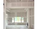 A spacious living room features a fireplace, large windows, and a tray ceiling under construction at 804 Edisto Ct., Myrtle Beach, SC 29588