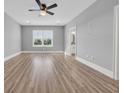 Neutral bedroom featuring light gray walls, white trim, a ceiling fan, and a large window at 186 Palmetto Harbour Dr., North Myrtle Beach, SC 29582