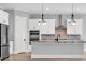 Modern kitchen featuring stainless steel appliances, granite countertops, pendant lighting, and white cabinets at 186 Palmetto Harbour Dr., North Myrtle Beach, SC 29582