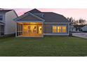The backyard features a covered screened-in porch for outdoor entertaining and a spacious lawn area at 3329 Sw Wood Stork Dr., Ocean Isle Beach, NC 28469
