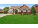 Single-story home boasts lush landscaping, vibrant foliage, and a welcoming facade at 826 Sand Binder Dr., Myrtle Beach, SC 29579