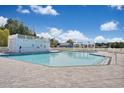 Large community pool with ample deck space, white fencing, a lifeguard stand, and pergola at 8711 Baton Rouge Ave Nw, Calabash, NC 28467