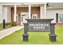 The Brunswick House, for members only, with manicured lawn and brick and white building in background at 8711 Baton Rouge Ave Nw, Calabash, NC 28467