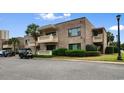 Brick condo building with small second-story balconies and golf cart parking at 10100 Lakeshore Dr. # C-1, Myrtle Beach, SC 29572