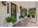 Inviting front porch with decorative ferns and an elegant front door with side windows at 120 Wraggs Ferry Rd., Georgetown, SC 29440