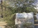 Whispering Pines Estates brick sign with mature foliage at 1208 Mackie Circle, Myrtle Beach, SC 29579