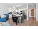 Bright kitchen with white cabinets, stainless steel appliances, gray island, and wood-look flooring at 1210 A S Ocean Blvd., Surfside Beach, SC 29575