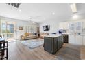Open-concept living space with wood floors, ceiling fan, stainless appliances, and light, airy decor at 1210 A S Ocean Blvd., Surfside Beach, SC 29575