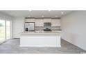 Modern kitchen featuring a center island, stainless steel appliances, and a sliding glass door to the patio at 144 Ashworth Dr., Tabor City, NC 28463
