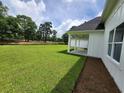 Backyard with a covered porch, an expansive lawn, mature trees and a view of a golf course at 1464 Hawthorn Dr., Pawleys Island, SC 29585