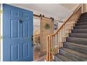 Inviting entryway featuring a blue front door, wooden sliding barn door, and carpeted stairs at 205 Lander Dr., Conway, SC 29526