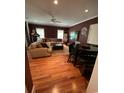 Cozy living area with dark red walls, a sectional sofa, adjacent dining area and hardwood floors at 234 Ave. Of The Palms, Myrtle Beach, SC 29579