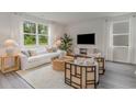 Cozy living room with a plush sofa, stylish chairs, a woven coffee table, large windows, and modern decor at 2824 Riverboat Way, Conway, SC 29526