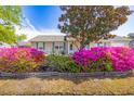 Inviting single-story home with blooming flowers and mature landscaping around the entrance at 349 Robin Hood Circle, Little River, SC 29566