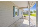 View of a cozy front porch showing white columns, blue shutters, and pea gravel landscaping at 349 Robin Hood Circle, Little River, SC 29566