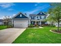 Charming two-story home with a well-manicured lawn, attached garage, and inviting entrance at 3613 Pitchers Pl., Little River, SC 29566