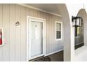 Condo entryway featuring a white door with glass, a wall-mounted lantern, and an arched walkway at 4409 Eastport Blvd. # E2, Little River, SC 29566