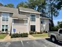 A close exterior daytime shot of the condo building with handicap parking in front of well maintained landscape at 4482 Little River Inn Ln. # 2004, Little River, SC 29566