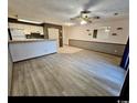 Living room featuring hardwood floors, updated ceiling fan, and half wall opening to the kitchen at 4482 Little River Inn Ln. # 2004, Little River, SC 29566