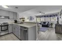 Open-concept living area with stylish furnishings, wood-look flooring, and a view to the adjacent kitchen at 5905 South Kings Hwy. # 4202, Myrtle Beach, SC 29575