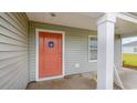 A welcoming view of the front porch showcasing the orange front door and siding at 71 Ashworth Dr., Tabor City, NC 28463