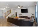 A spacious living room with hardwood floors, a cozy couch, and a staircase at 808 Wild Leaf Loop, Conway, SC 29526