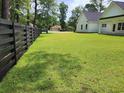 Large, grassy backyard with a wooden fence and partial view of the home at 974 Crooked Oak Dr., Pawleys Island, SC 29585