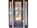 Elegant front door with glass panels, framed by sidelights, providing a welcoming entrance to the home at 974 Crooked Oak Dr., Pawleys Island, SC 29585